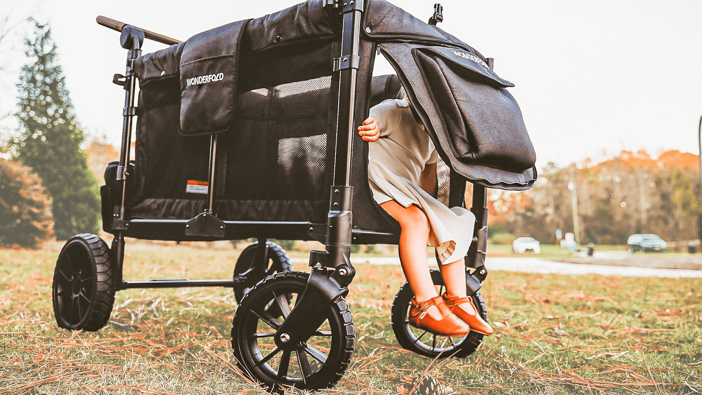 W4 Luxe Quad Stroller Wagon - Lifestyle Image of Toddler Coming out of W4 Luxe Quad Stroller Wagon Black Camo