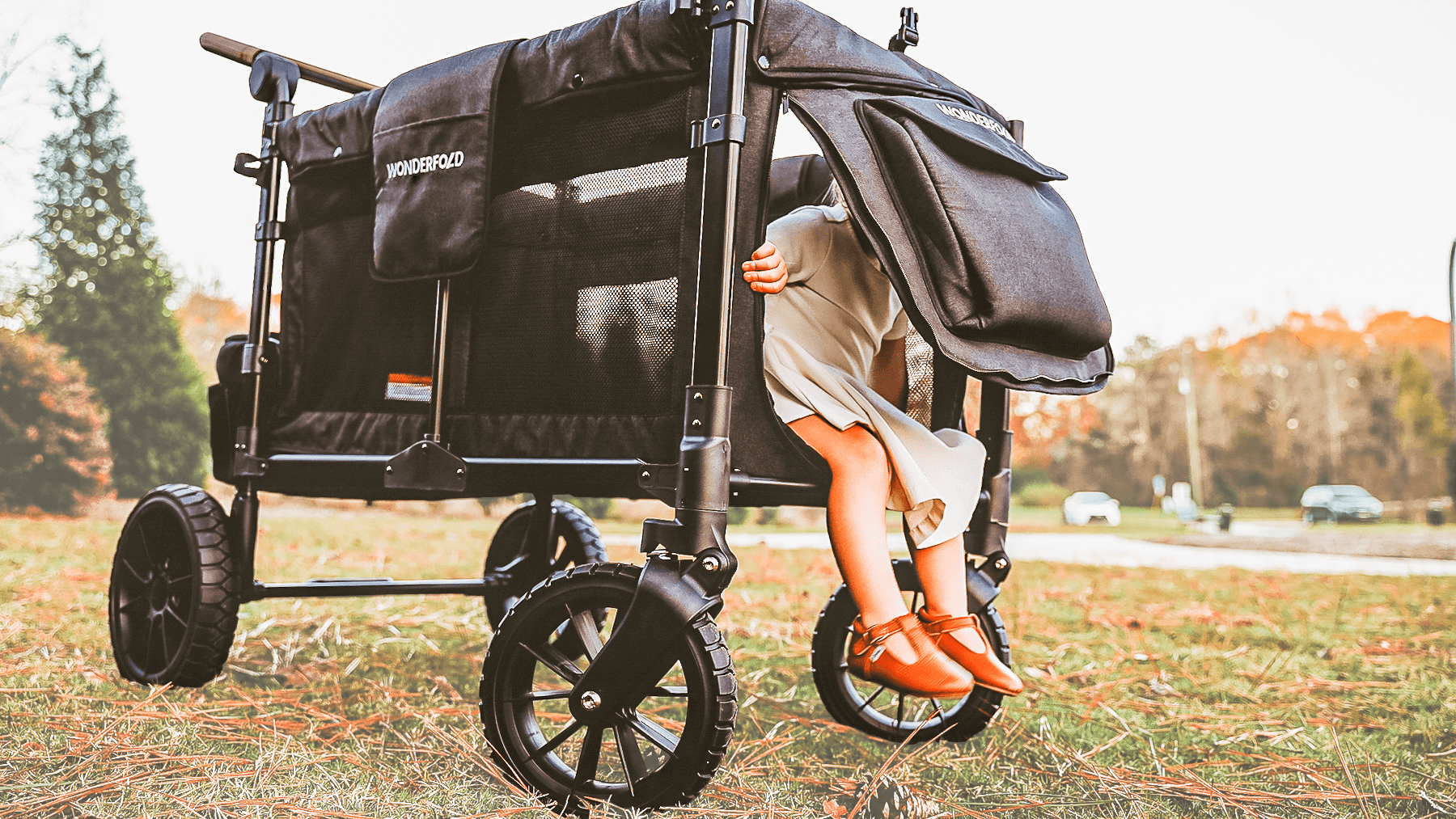 W4 Luxe Quad Stroller Wagon - Lifestyle Image of Toddler Coming out of W4 Luxe Quad Stroller Wagon Black Camo