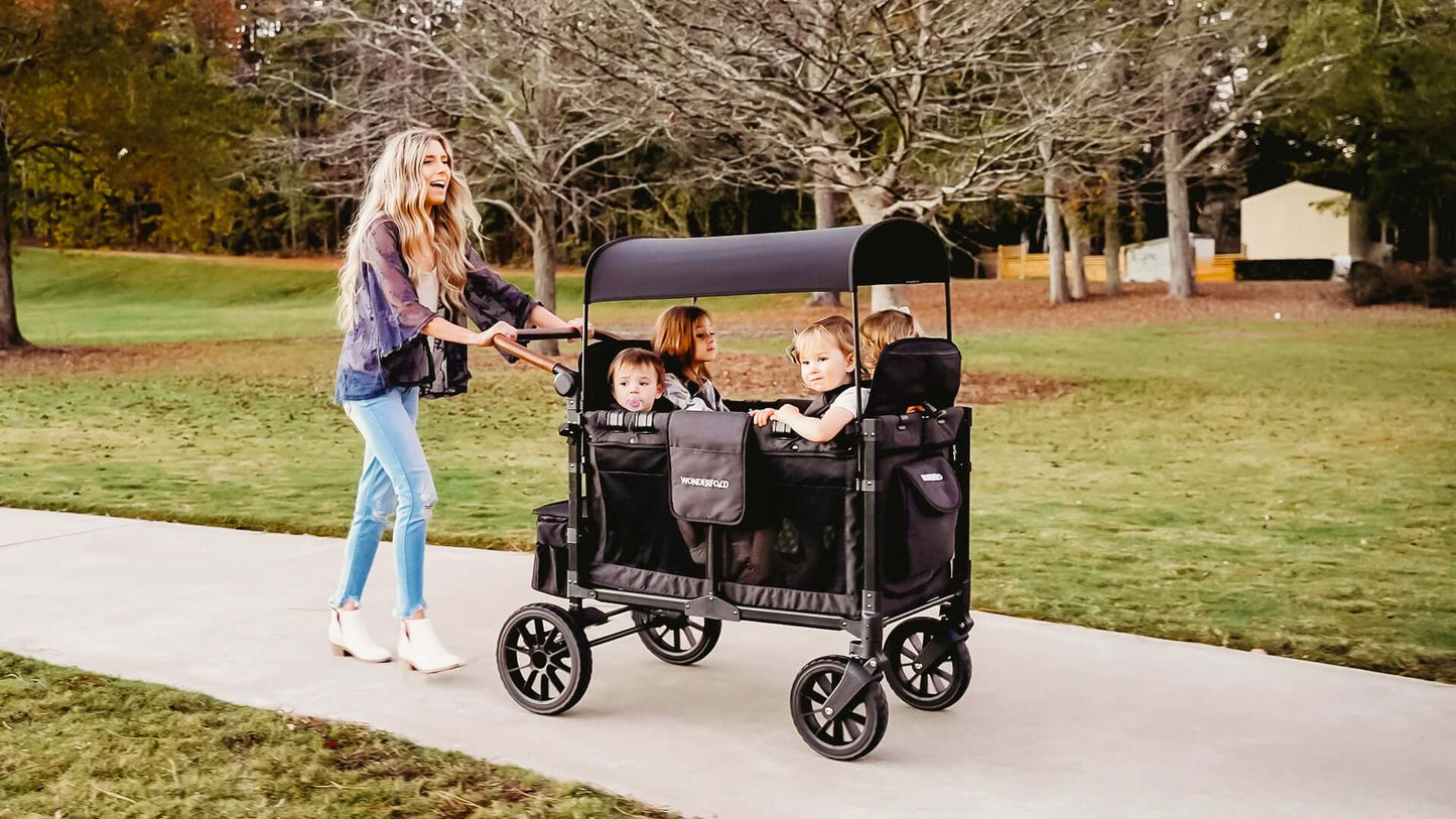W4 Luxe Quad Stroller Wagon - Lifestyle Image Front Inclined View of Mother with Toddler's on W4 Luxe Quad Stroller Wagon