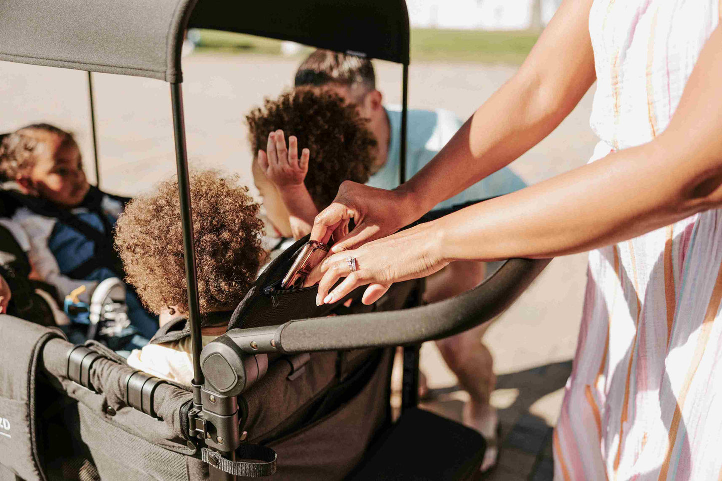 W4 Elite Quad Stroller Wagon - Lifestyle Image of Parent Storing Mobile in W4 Elite Quad Stroller Wagon Black Camo