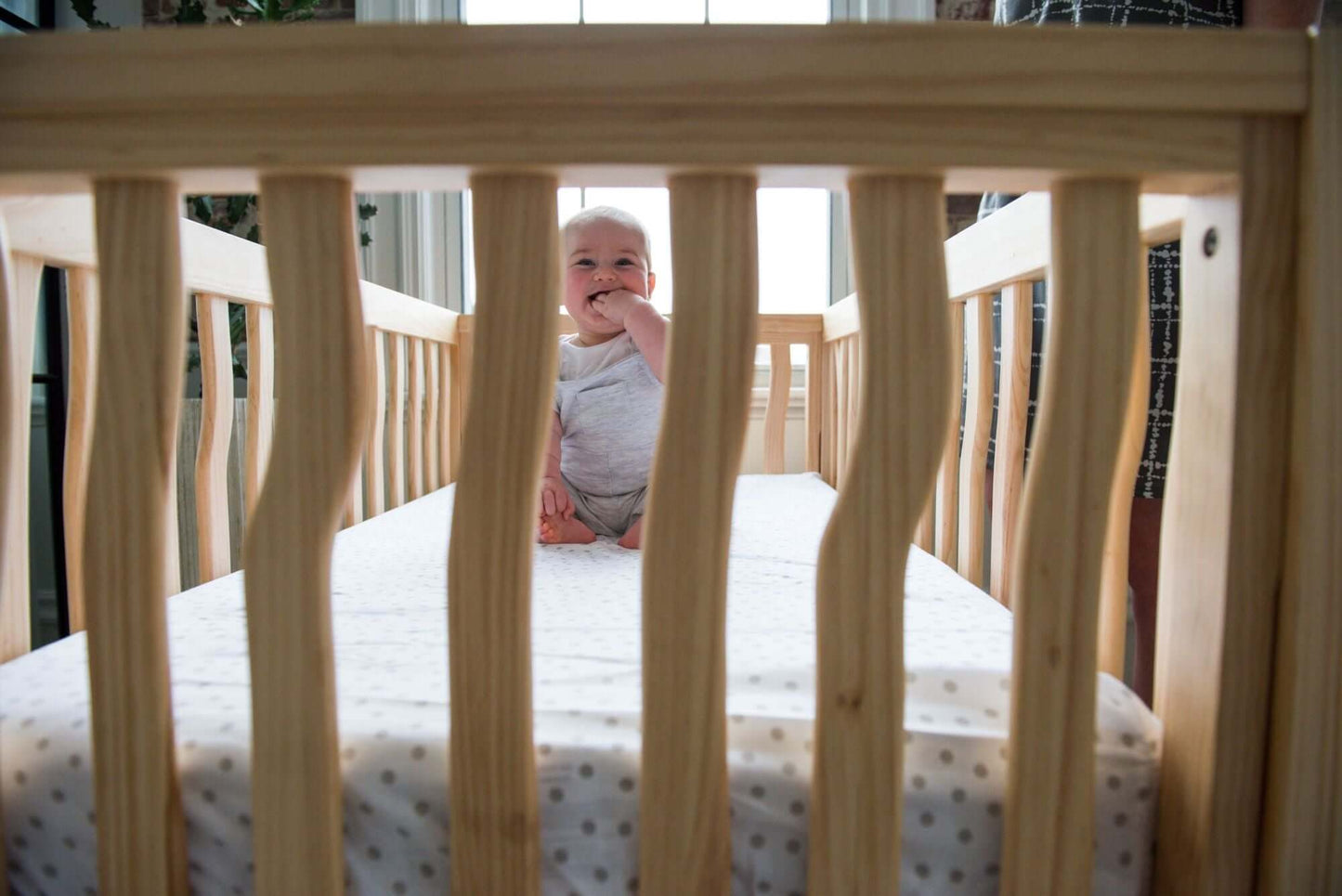 Branch 4 in 1 Convertible Crib - Zoomed Front View Lifestyle Image of 4 in 1 Convertible Crib Acacia with Baby Inside