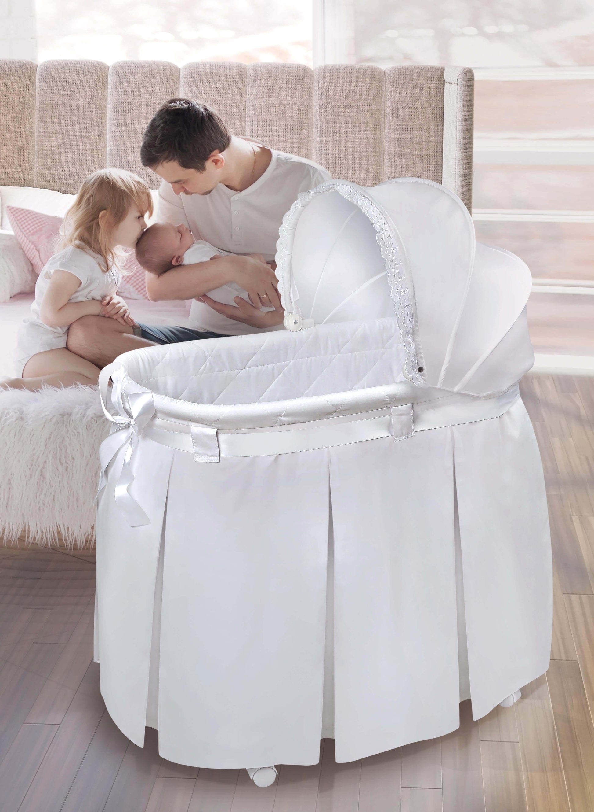 Wishes Oval Bassinet - Lifestyle Image of Mother Holding Baby Besides Wishes Oval Bassinet White Bedding