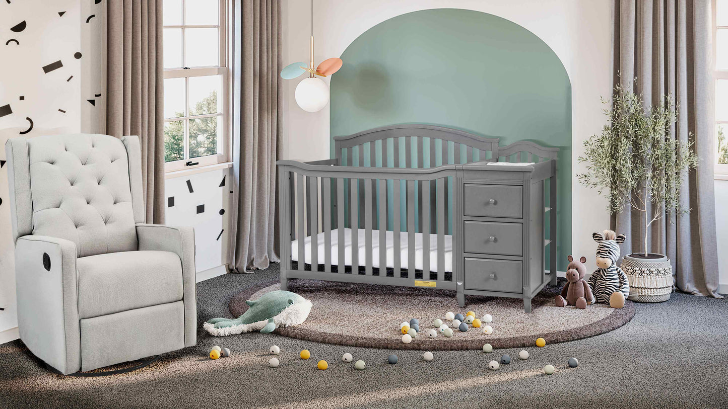 Kali II 4-in-1 Crib and Changer - Lifestyle Image Inclined Side View of Kali II 4-in-1 Crib and Changer Gray with Glider Chair