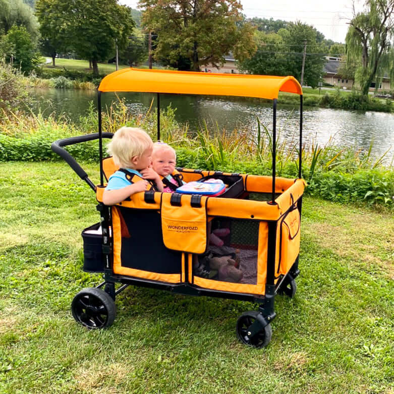 W4 Original Quad Stroller Wagon - Lifestyle Image Side View of Wagon Orange