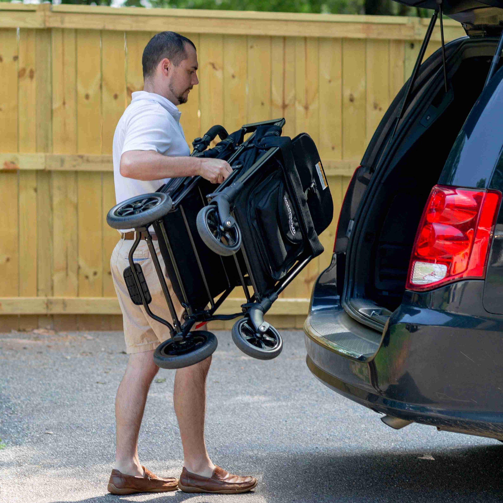 W2 Original + Double Stroller Wagon - Lifestyle Image of Man Placing W2 Original + Double Stroller Wagon Black In Car