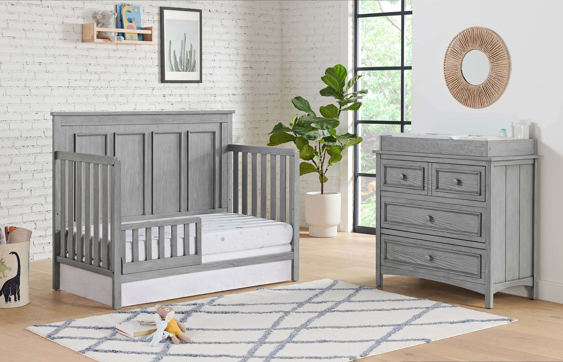 Bennett 4-in-1 Convertible Crib - Lifestyle Image Inclined Side View of Bennett 4-in-1 Convertible Crib Rustic Gray with Guard Rail