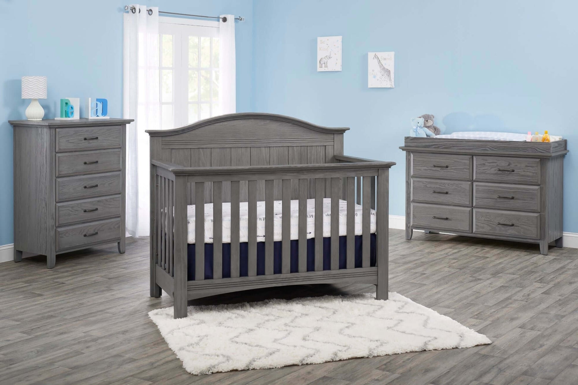 Chandler Changing Topper - Lifestyle Image Inclined Side View of Chandler Changing Topper Gray on Top of 6 Drawer Dresser Beside Crib