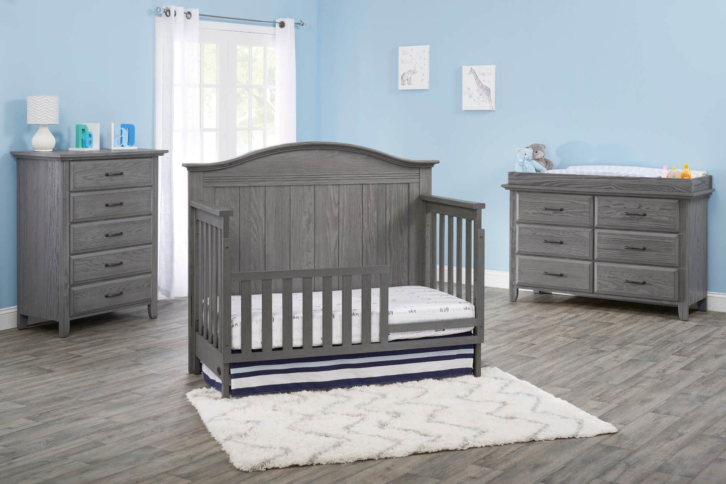 Chandler 4 In 1 Convertible Crib - Lifestyle Image Inclined Side View of Chandler 4 In 1 Convertible Crib Graphite Gray with Guard Rail