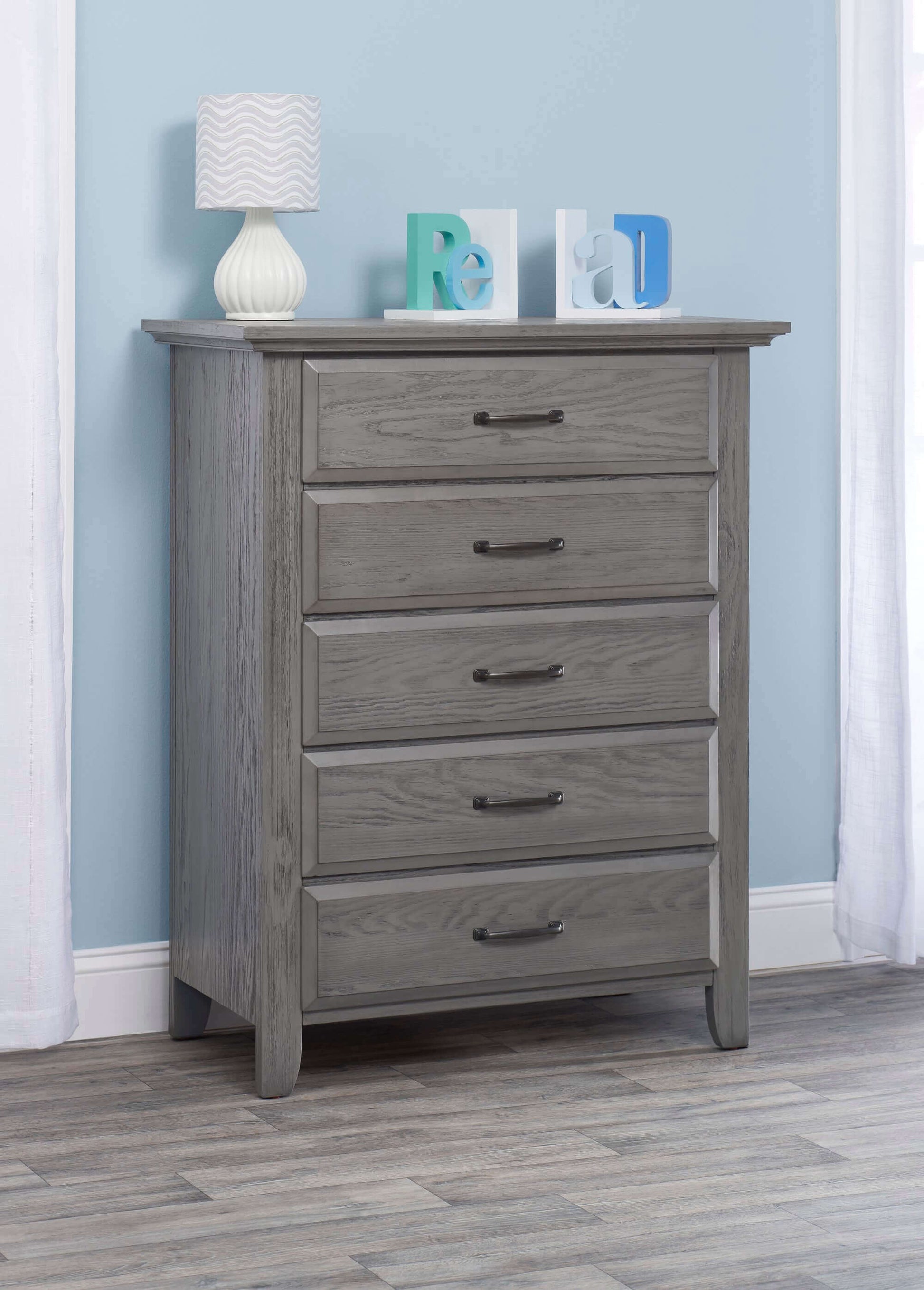 Chandler 5 Drawer Chest - Lifestyle Image Inclined Side View of Chandler 5 Drawer Chest Rustic Gray