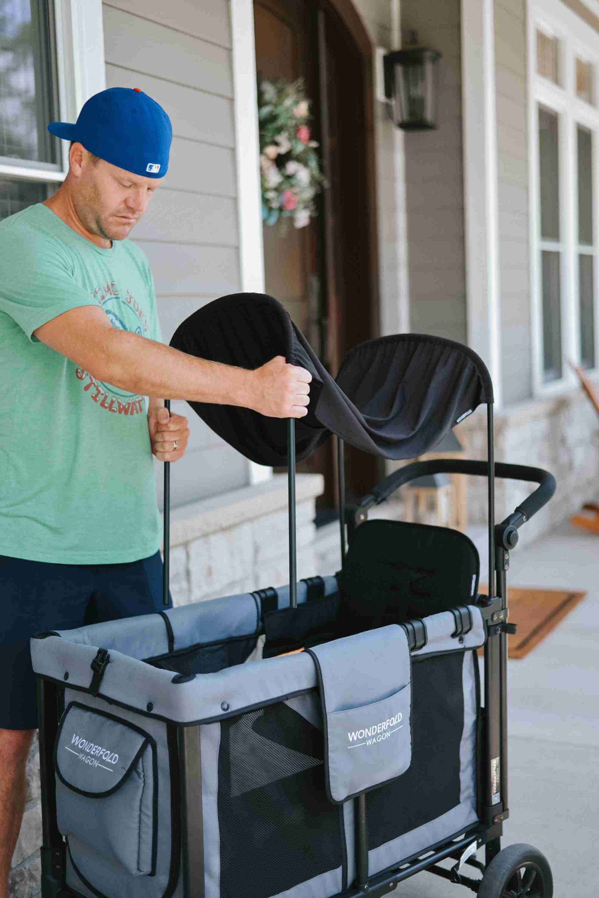 W2 Original + Double Stroller Wagon - Lifestyle Image of Man Installing Canopy for W2 Original + Double Stroller Wagon Gray