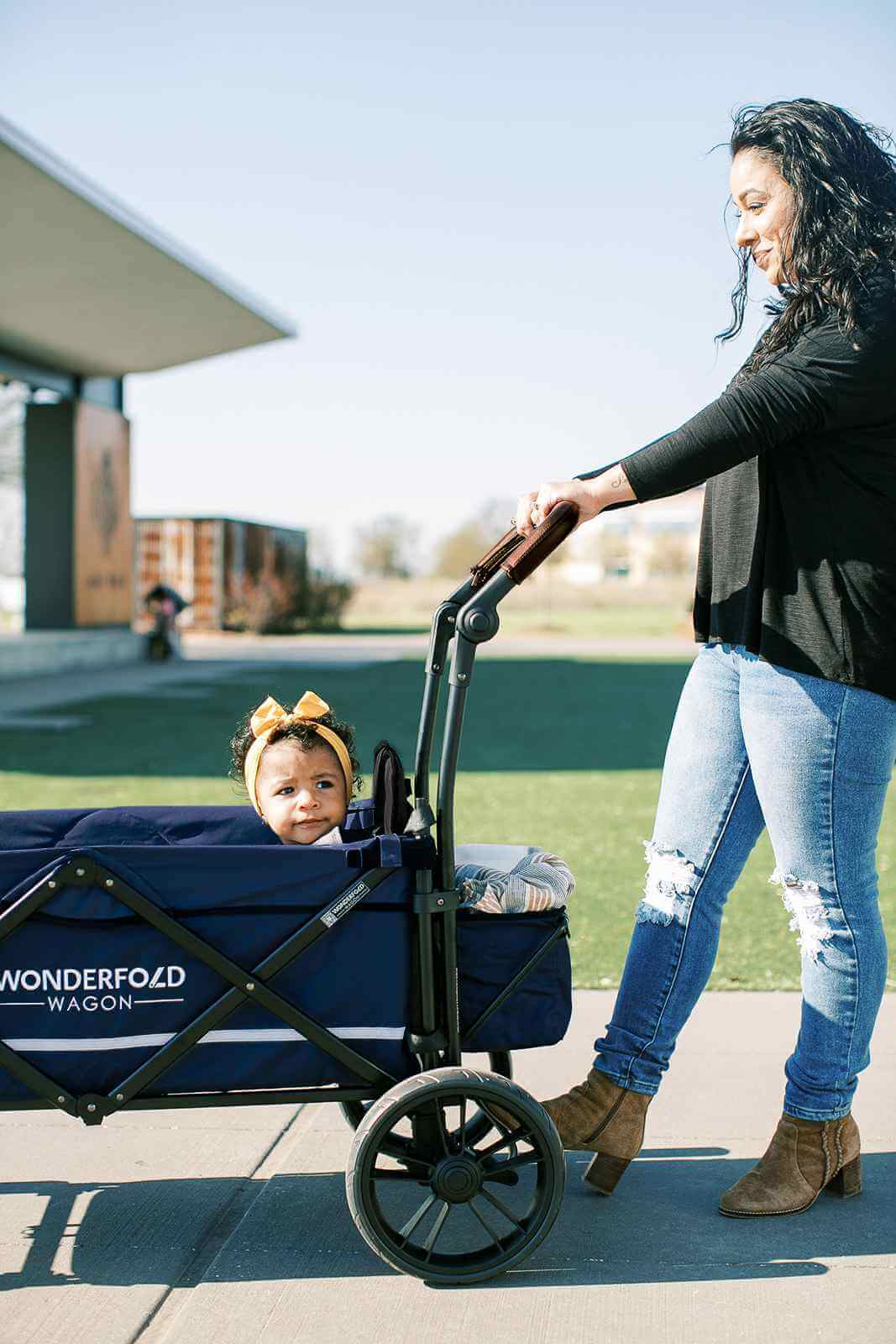 X2 Double Stroller Wagon - Lifestyle Image of Mother Holding Push Handle of X2 Double Stroller Wagon with Baby Inside Wagon Navy