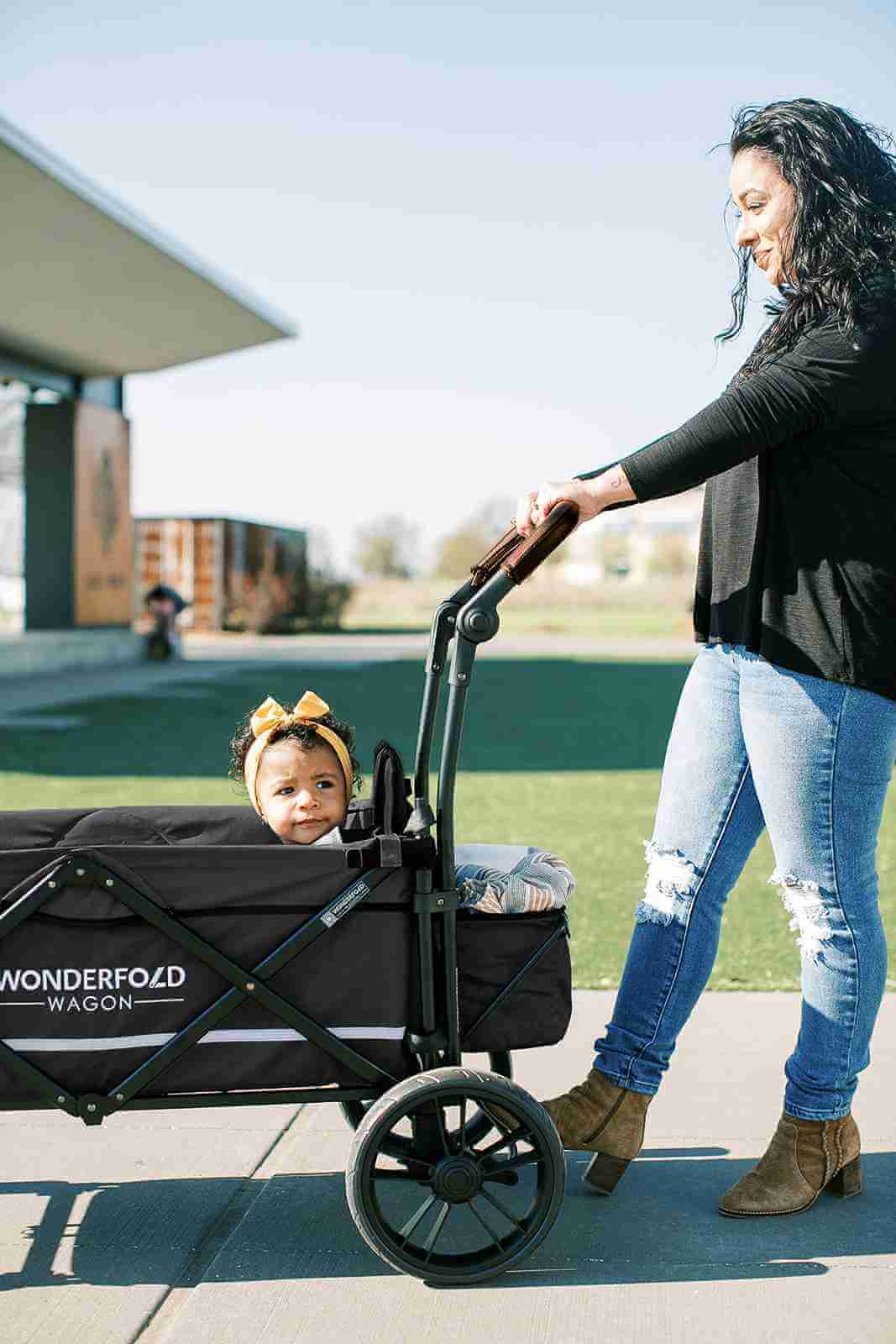 X2 Double Stroller Wagon - Lifestyle Image of Mother Holding Push Handle of X2 Double Stroller Wagon with Baby Inside Wagon Black