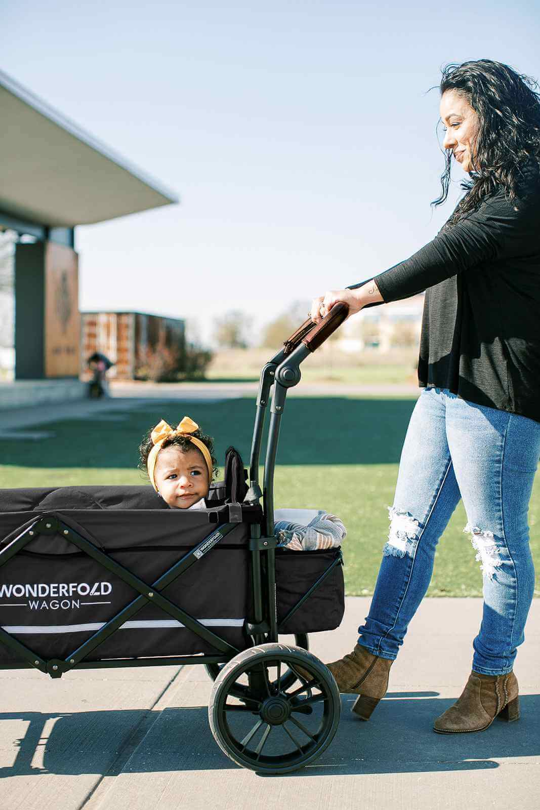 X2 Double Stroller Wagon - Lifestyle Image of Mother Holding Push Handle of X2 Double Stroller Wagon with Baby Inside Wagon Gray