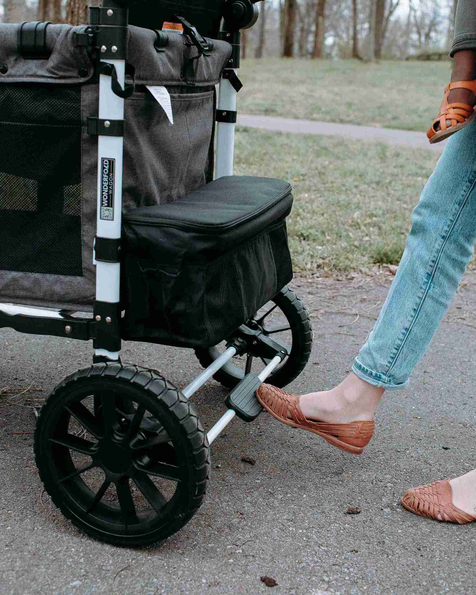 W4 Luxe Quad Stroller Wagon - Lifestyle Image Zoomed View of Brake Usage of W4 Luxe Quad Stroller Wagon Black Camo
