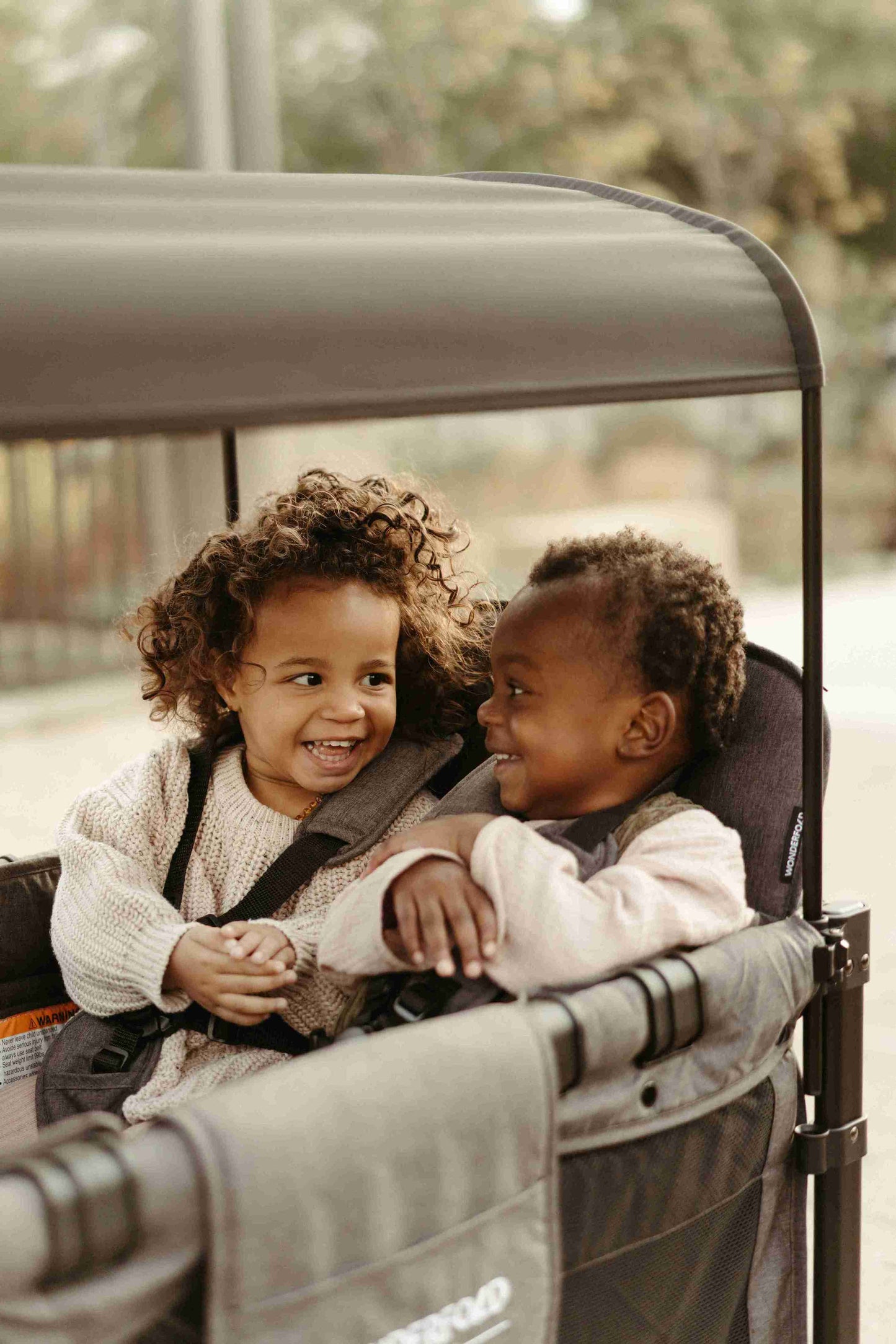 W4 Luxe Quad Stroller Wagon - Zoomed Lifestyle Image of Toddler Playing in W4 Luxe Quad Stroller Wagon Gray