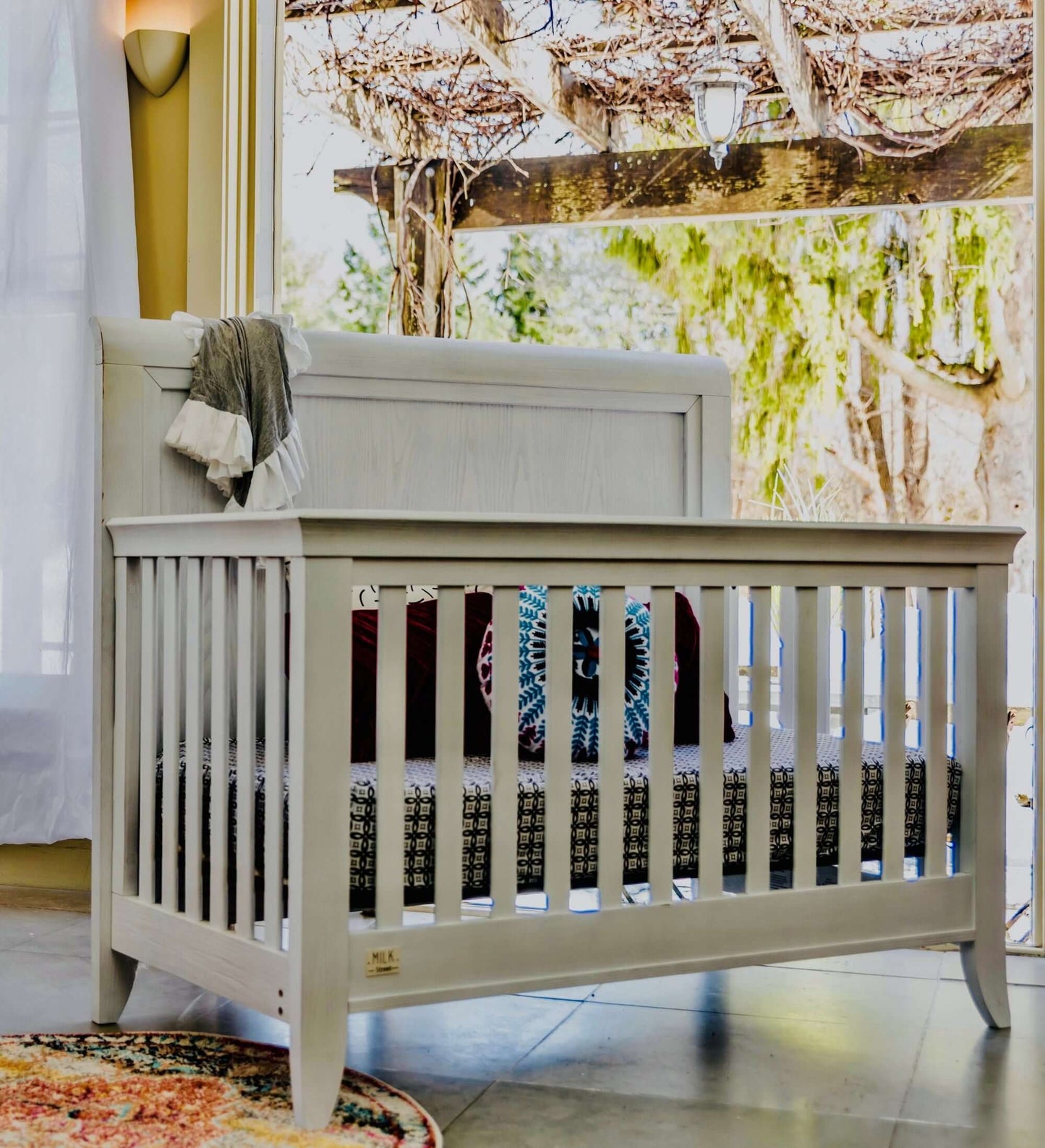 Cameo Sleigh 4-in-1 Convertible Crib - Lifestyle Image Side View of Sleigh 4-in-1 Convertible Crib Steam-1