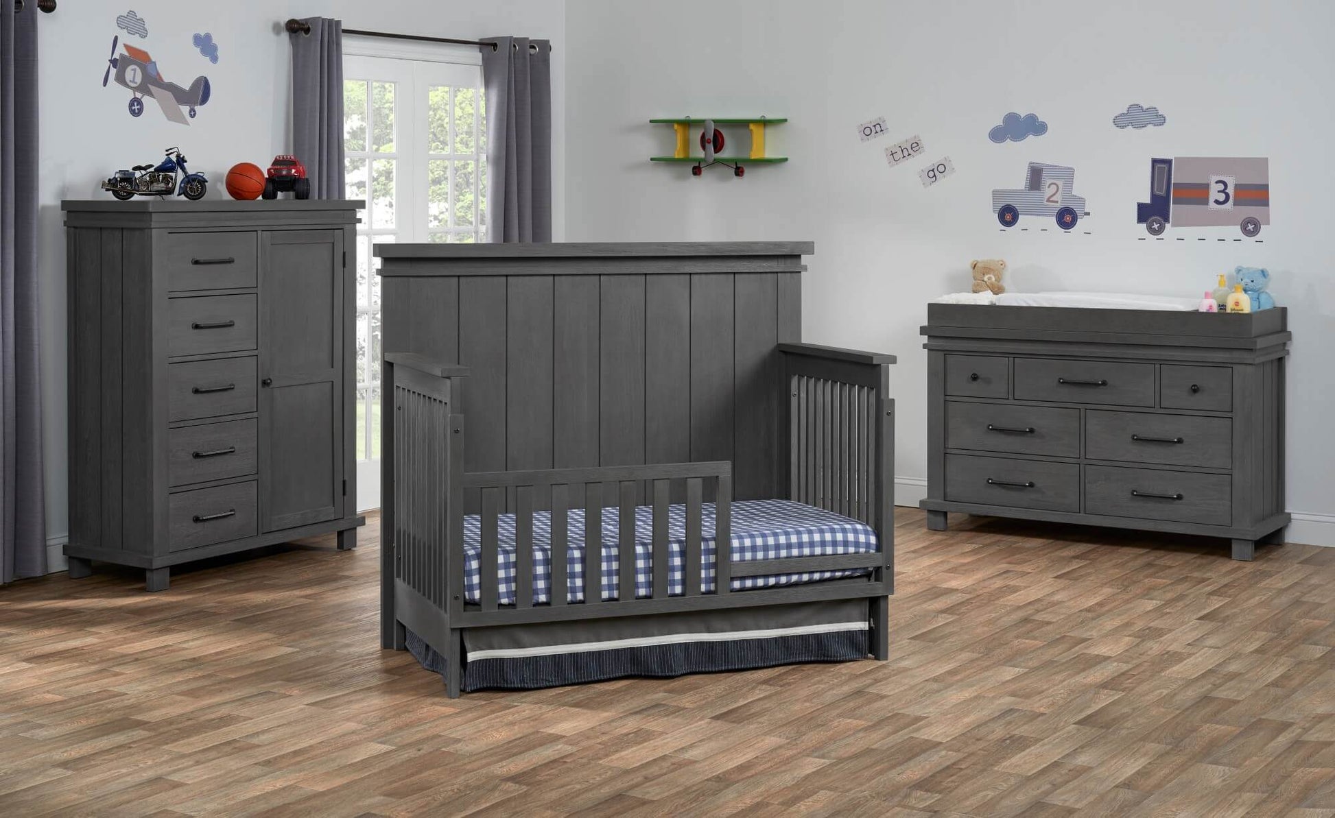 Hampton 4 In 1 Convertible Crib - Lifestyle Image Inclined Side View of Hampton 4 In 1 Convertible Crib Canyon Gray with Guard Rail