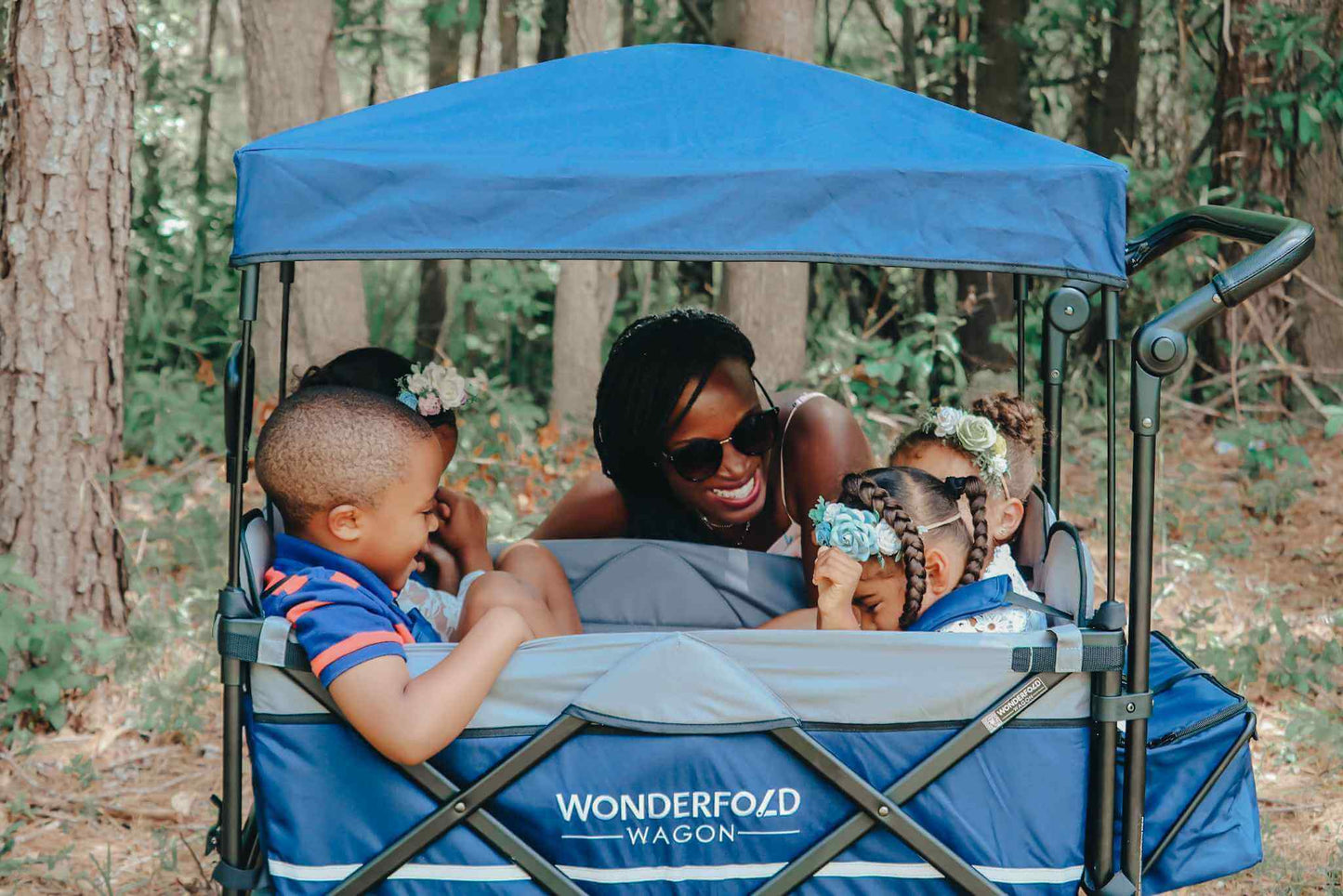 X4 Push + Pull Quad Stroller Wagon - Lifestyle Image Side View of Babies Playing in X4 Push + Pull Quad Stroller Wagon Navy