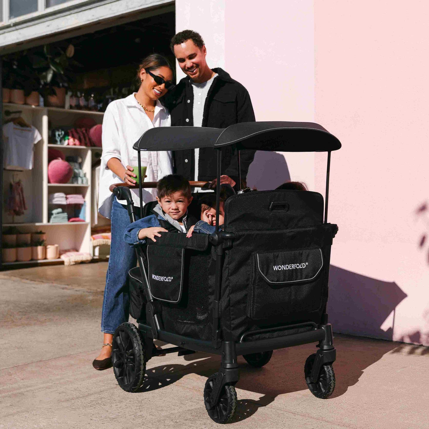 L4 Quad Stroller Wagon - Lifestyle Image Inclined View of Family with Children's on L4 Quad Stroller Wagon Black With Handle