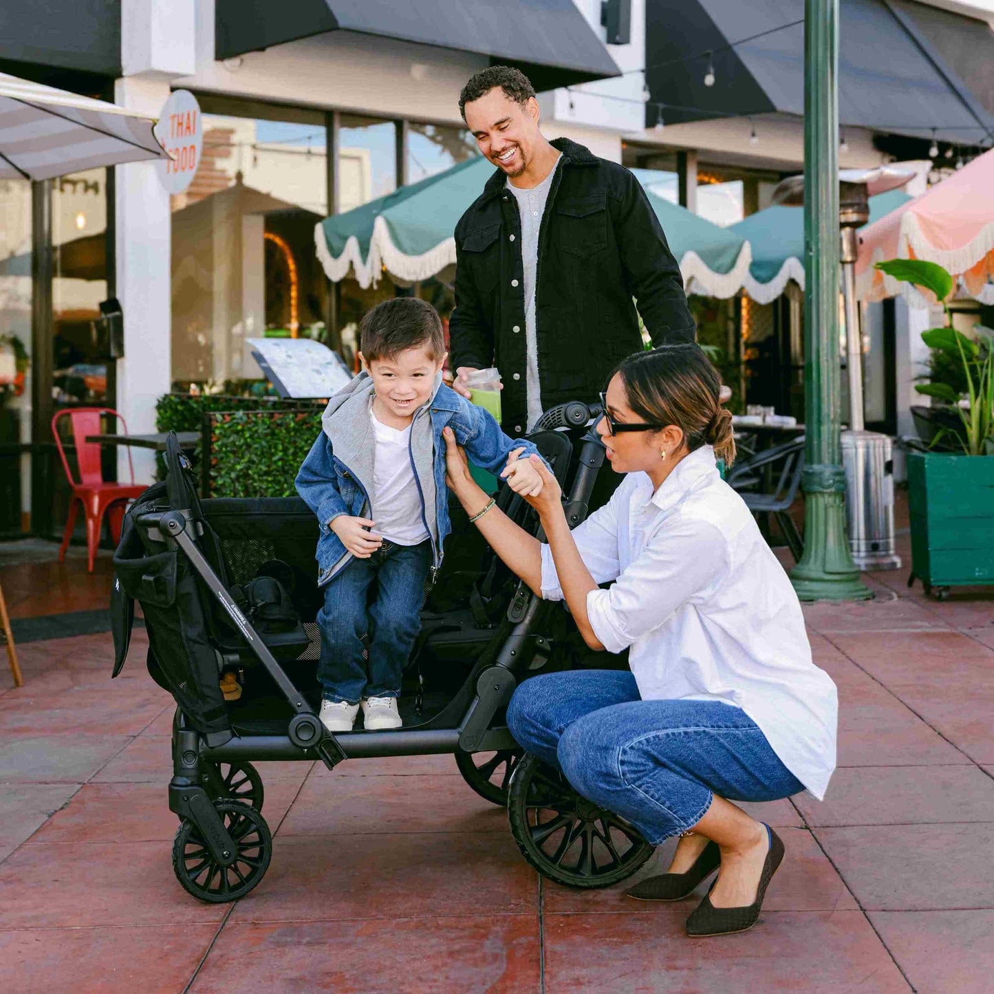 L4 Quad Stroller Wagon - Lifestyle Image Side View of the L4 Quad Stroller Wagon Black Child Hopping