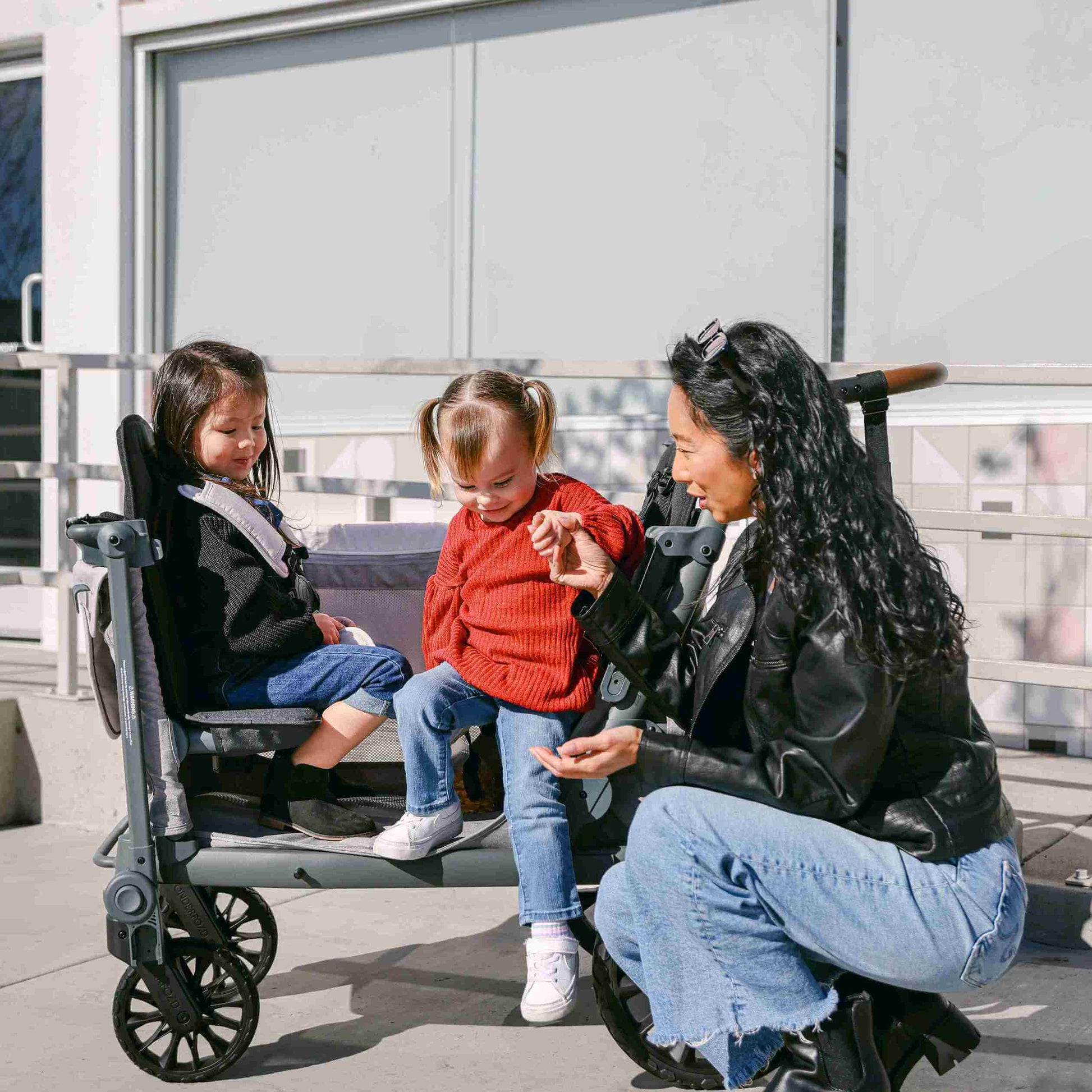 L4 Quad Stroller Wagon - Lifestyle Image Mother Helping Child to Get Out of L4 Quad Stroller Wagon Gray