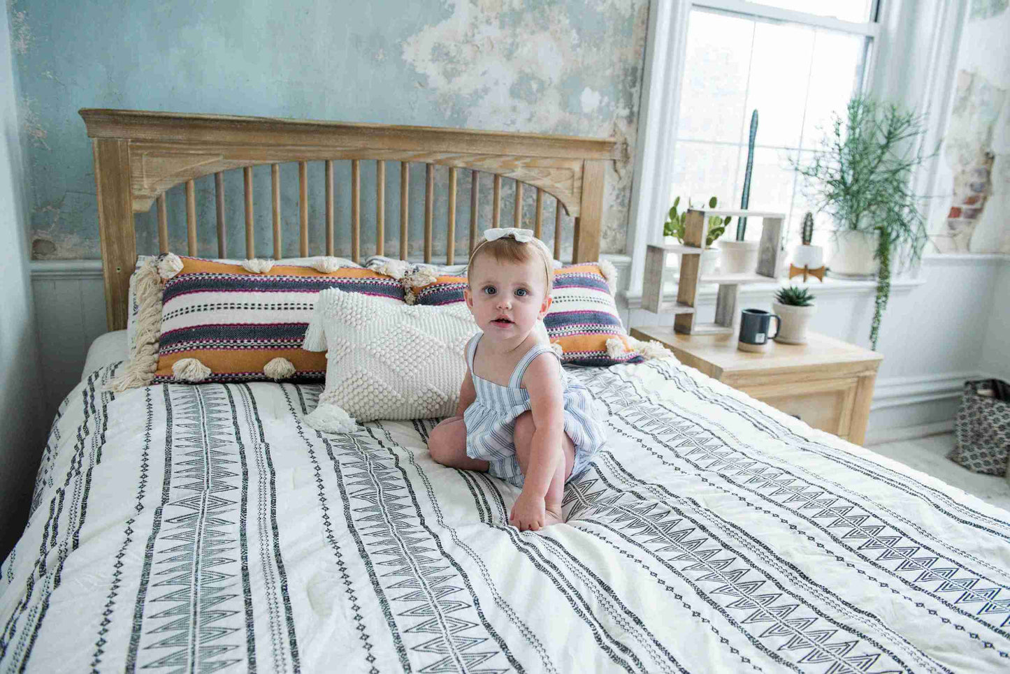 Cameo Oval Convertible Crib - Lifestyle Image Front View of Oval Toddler Bed Toast with Baby