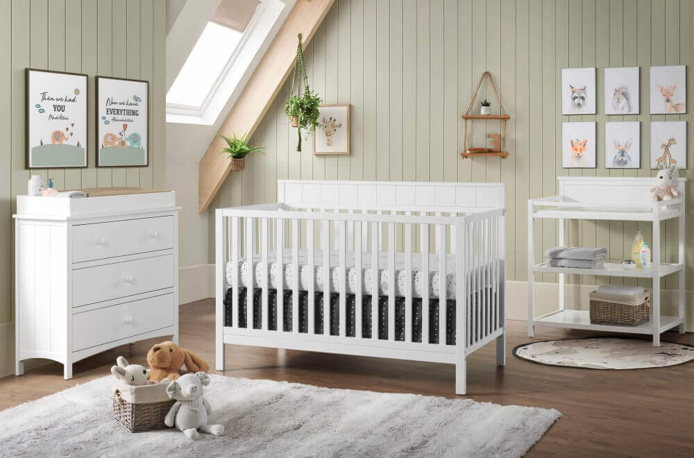 Logan 4-in-1 Convertible Crib - Lifestyle Image Inclined Side View of Logan 4-in-1 Convertible Crib Snow White with 3 Drawer Dresser