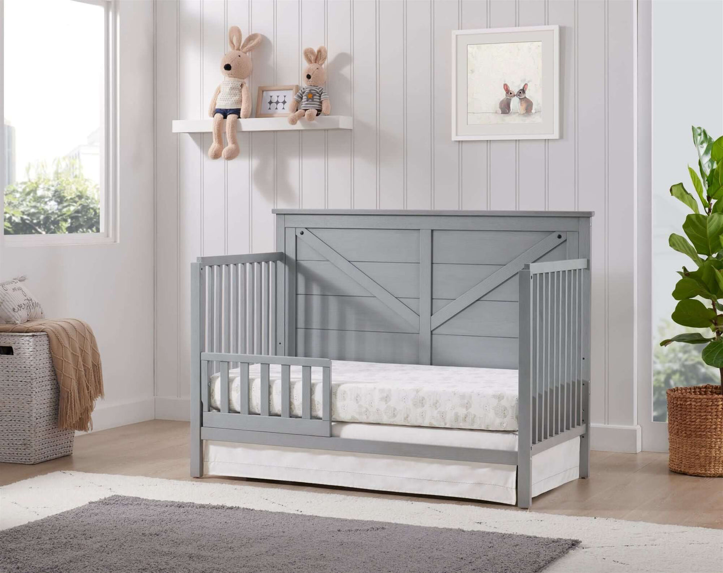 Montauk 4-in-1 Convertible Crib - Lifestyle Image Inclined Side View of Montauk 4-in-1 Convertible Crib Farmhouse Gray with Guard Rail