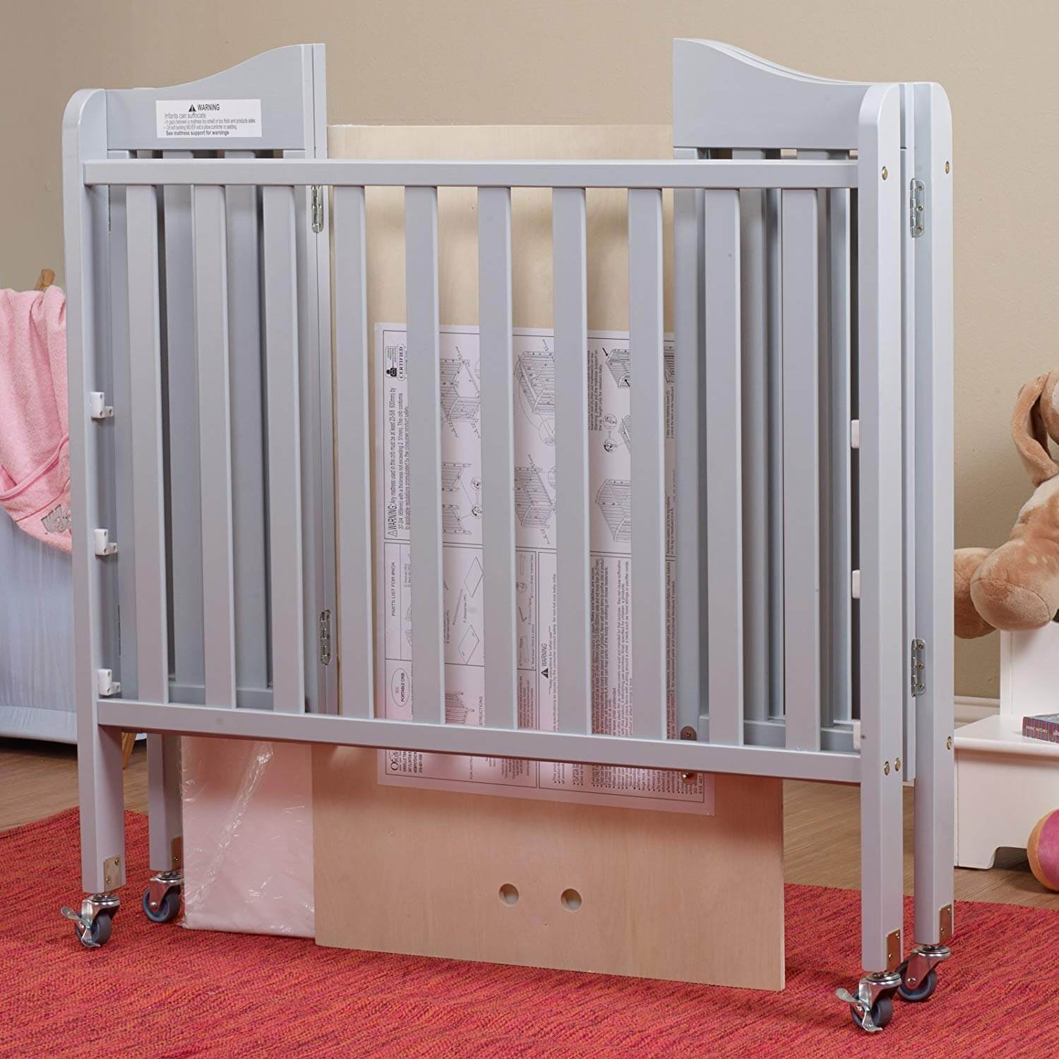 Noa Three level Mini Portable Crib  -Lifestyle Image Inclined Side View of Folded Noa Three level Mini Portable Crib White