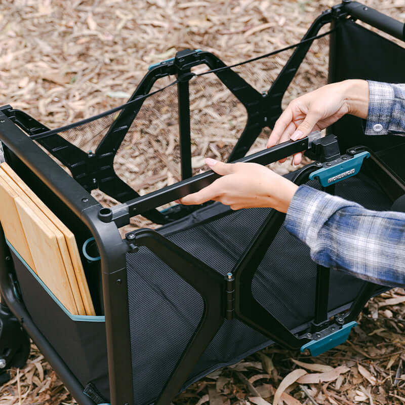 S5 Convertible Utility Wagon - Zoomed View Lifestyle Image of Woman Unfolding S5 Convertible Utility Wagon Black