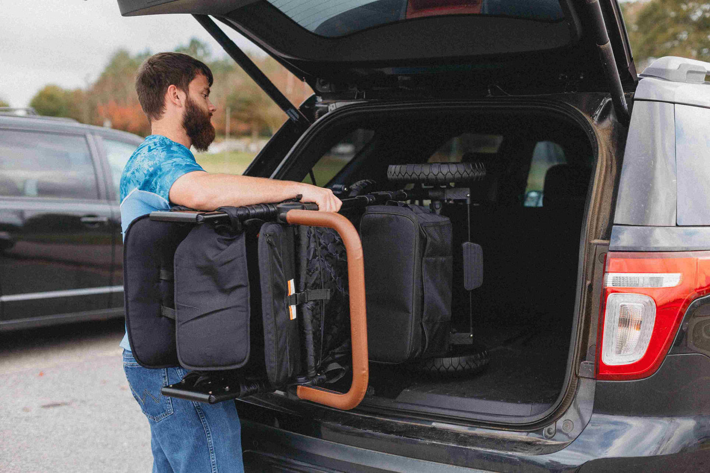 W2 Luxe Double Stroller Wagon - Lifestyle Image of Man Placing Folded W2 Luxe Double Stroller Wagon in his Car