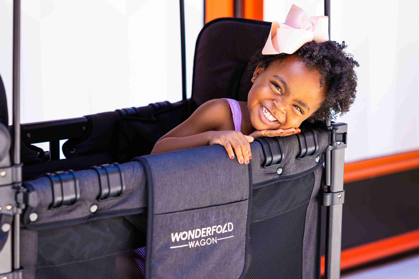 W2 Luxe Double Stroller Wagon - Zoomed Lifestyle Image of Toddler Peaking From W2 Luxe Double Stroller Wagon Gray