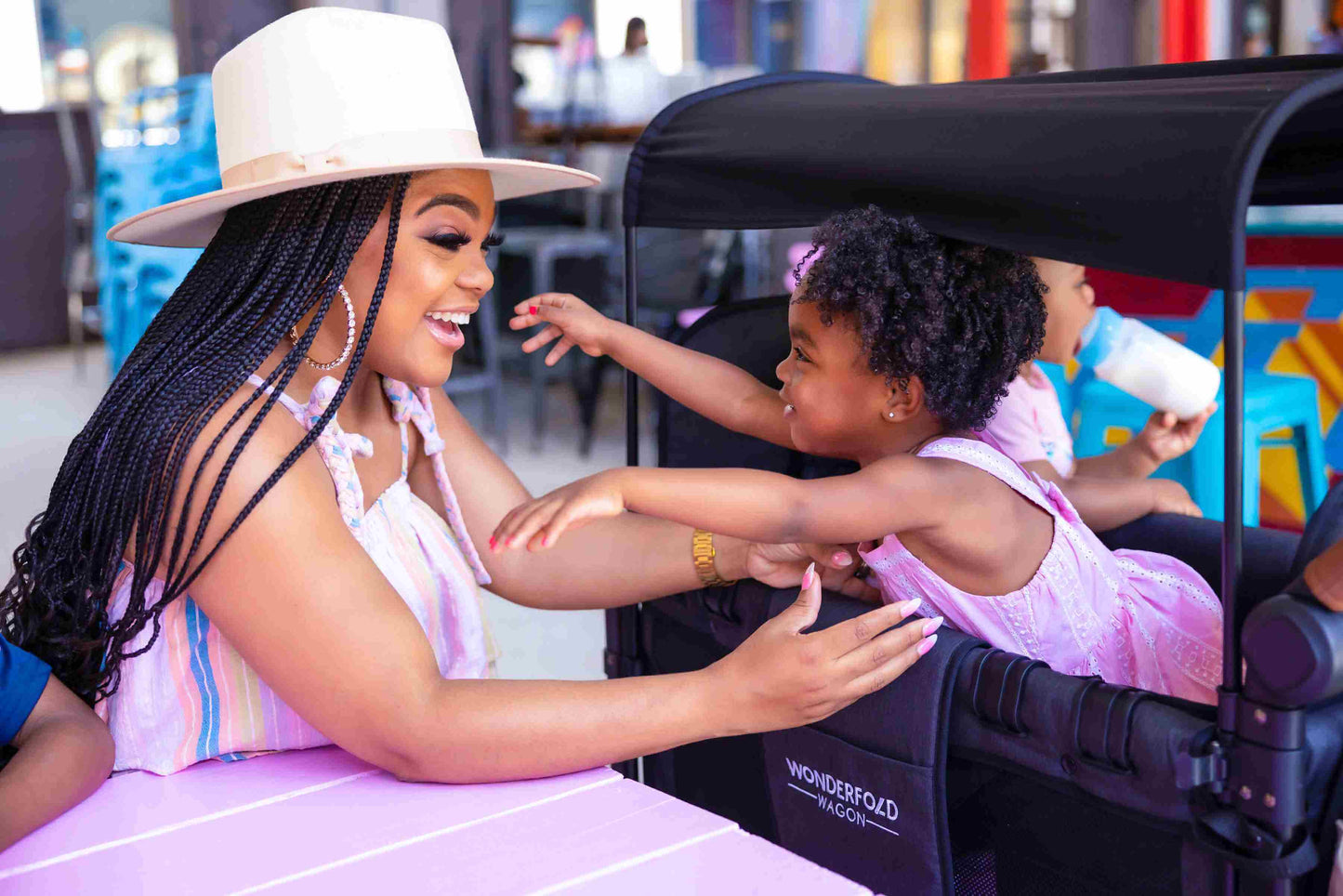 W2 Luxe Double Stroller Wagon - Lifestyle Image of Mother Playing with the Baby on W2 Luxe Double Stroller Wagon Black