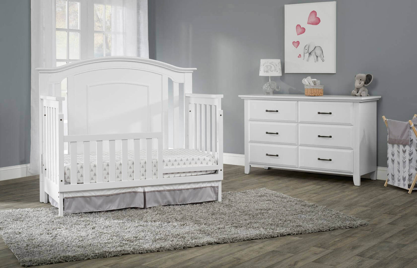 Willowbrook 4-in-1 Convertible Crib - Lifestyle Image Inclined Side View of Willowbrook 4-in-1 Convertible Crib White with Guard Rail