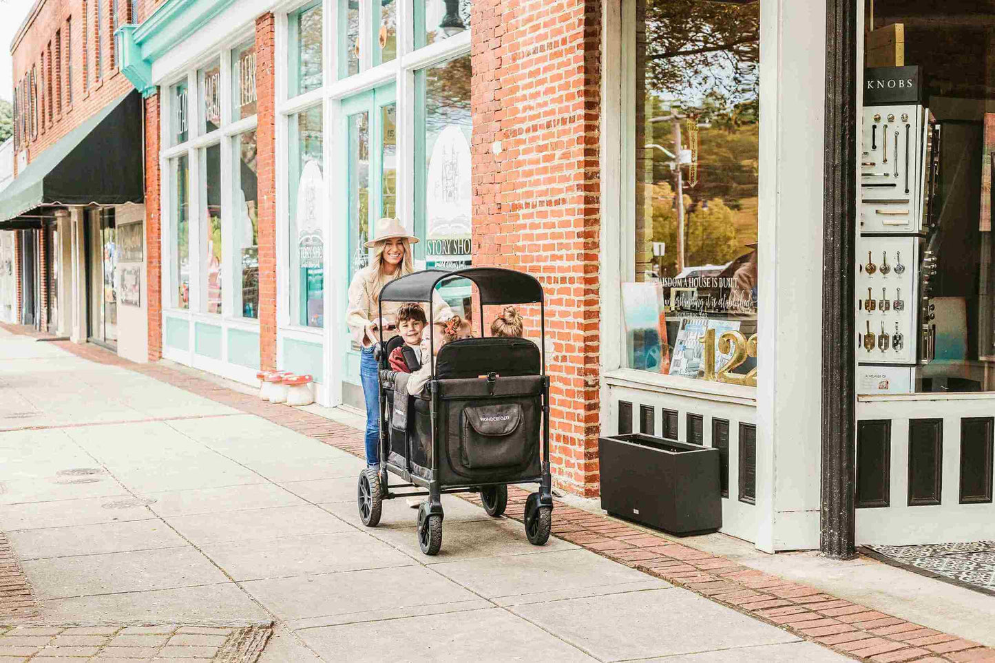 W4 Luxe Quad Stroller Wagon - Lifestyle Image Front View of Mother with Toddler's on W4 Luxe Quad Stroller Wagon