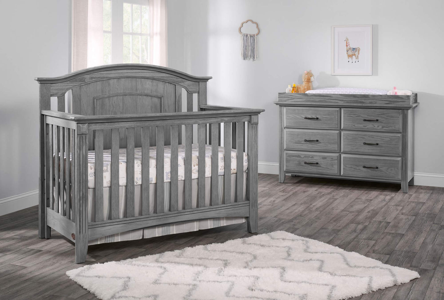 Willowbrook 4-in-1 Convertible Crib - Lifestyle Image Inclined Side View of Willowbrook 4-in-1 Convertible Crib Graphite Gray