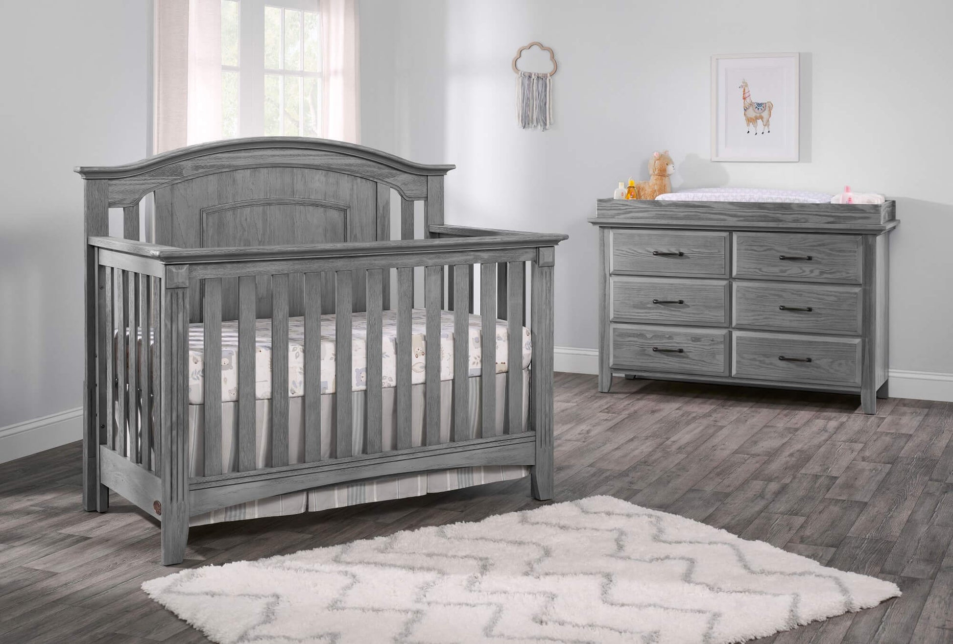 Willowbrook 4-in-1 Convertible Crib - Lifestyle Image Inclined Side View of Willowbrook 4-in-1 Convertible Crib Graphite Gray