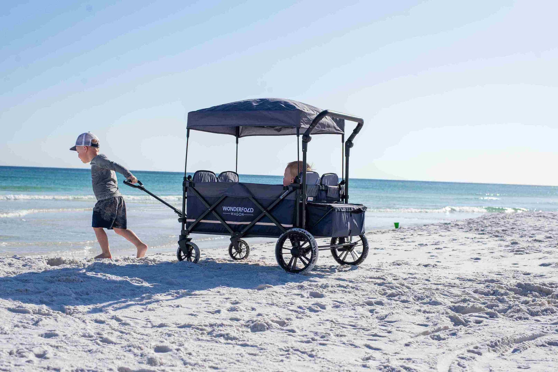 X4 Push + Pull Quad Stroller Wagon - Lifestyle Image of Toddler Holding Pull Handle of X4 Push + Pull Quad Stroller Wagon Navy