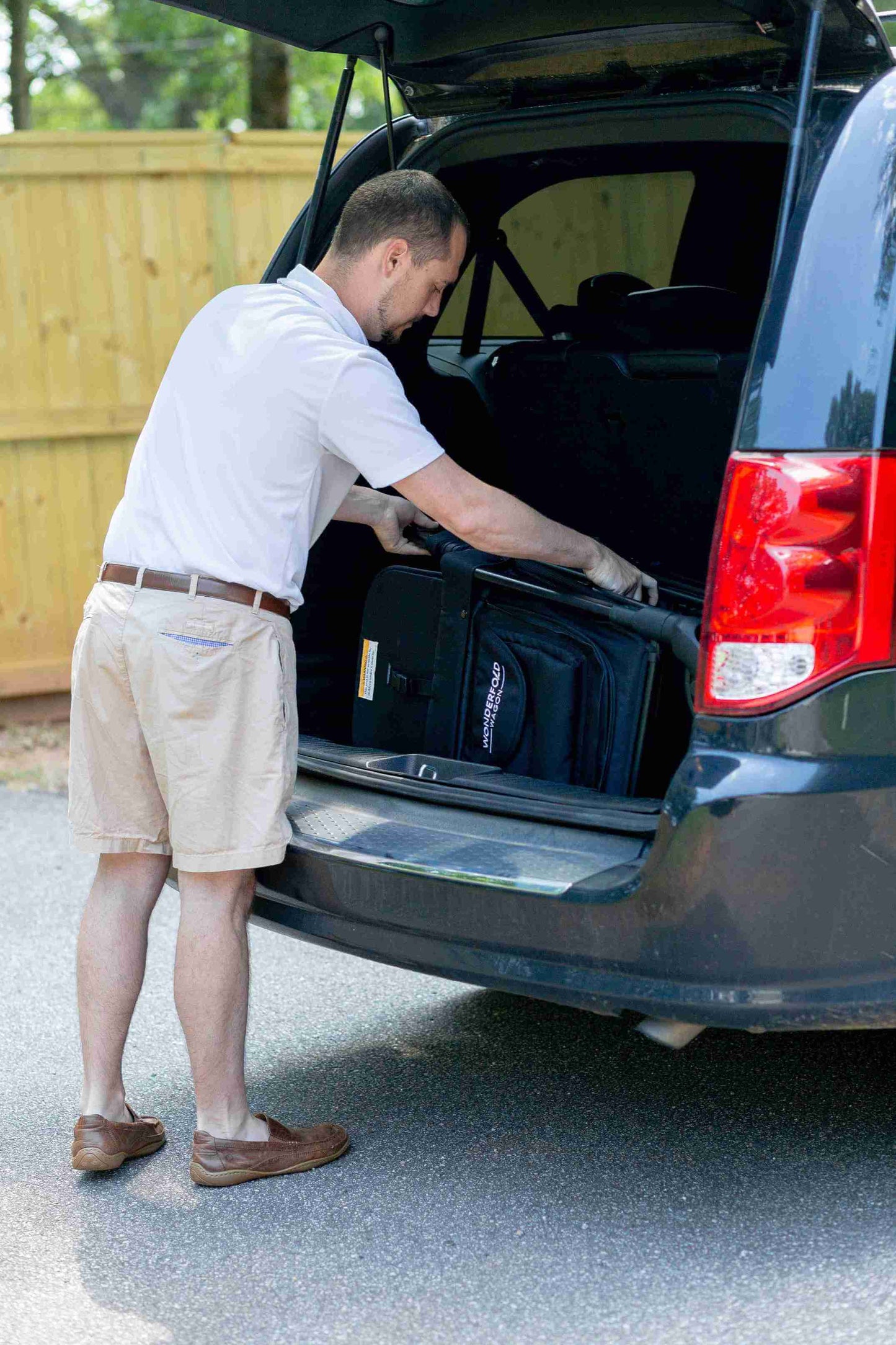 W2 Original + Double Stroller Wagon - Lifestyle Image of Man Placing W2 Original + Double Stroller Wagon Black In Car -1