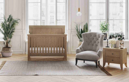 Cameo Oval Convertible Crib - Lifestyle Image Front View of Oval Toddler Bed Toast with 2 Drawer Nightstand